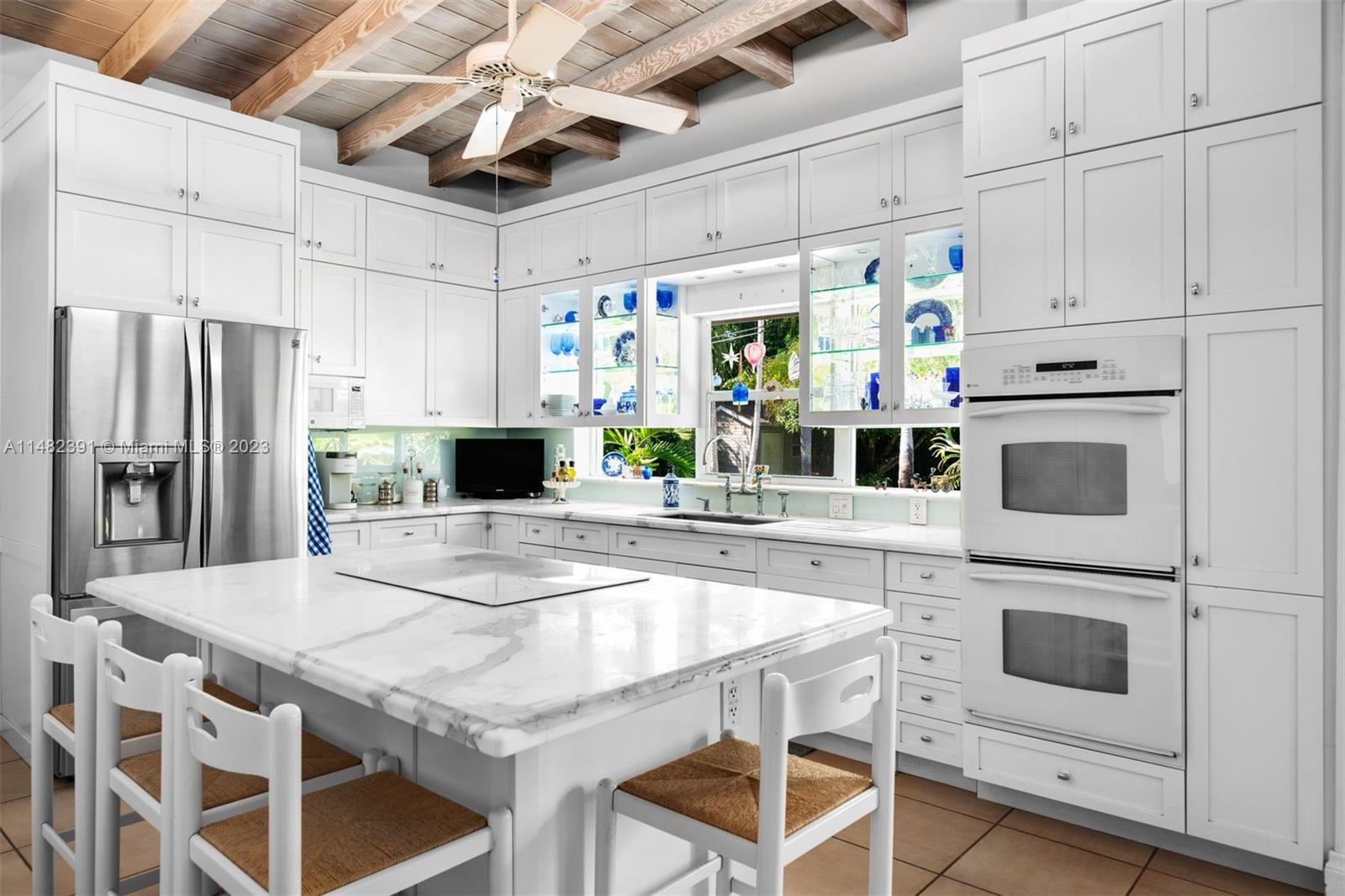 12510 Moss Ranch Road Pinecrest, FL 33156 - Photo 8 of 30 a kitchen with stainless steel appliances white cabinets and wooden floor