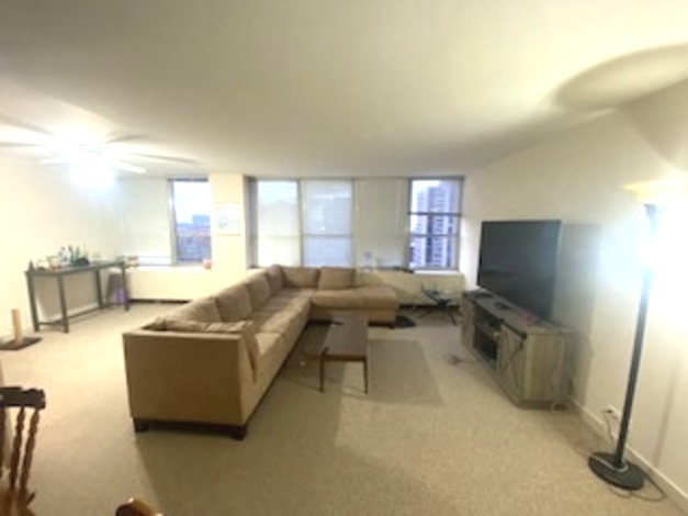 655 West Irving Park Road, Unit 1104 Chicago, IL 60613 - Photo 13 of 26 a living room with furniture and a flat screen tv