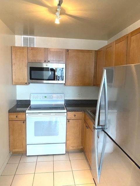 655 West Irving Park Road, Unit 1104 Chicago, IL 60613 - Photo 5 of 26 a kitchen with a stove and a refrigerator