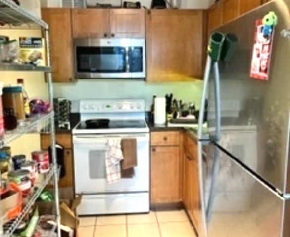655 West Irving Park Road, Unit 1104 Chicago, IL 60613 - Photo 7 of 26 a kitchen with stainless steel appliances kitchen island granite countertop a stove a microwave and a sink