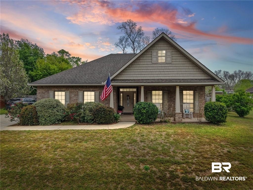 2570 Pecan Pointe Drive Semmes, AL 36575 - Photo 21 of 22 View of front facade featuring a yard, covered porch, brick siding, and roof with shingles