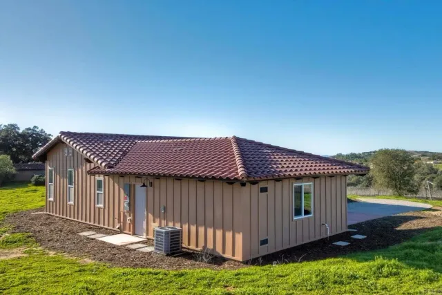 a view of a house with a yard and sitting area