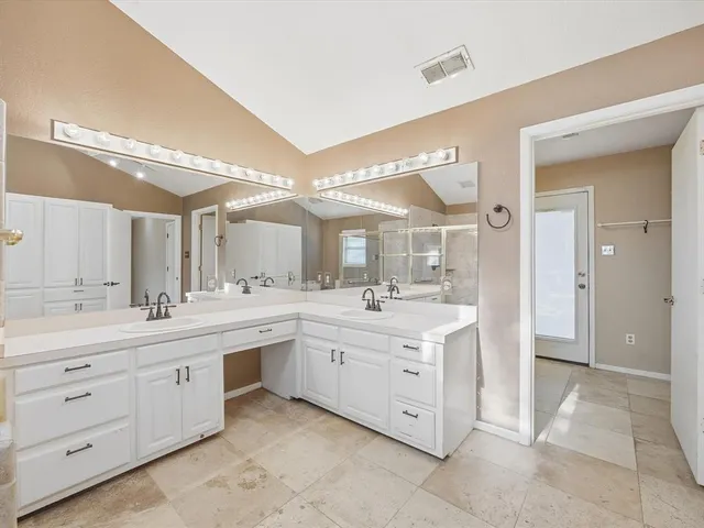 a large bathroom with a double vanity sink a large mirror and a bathtub