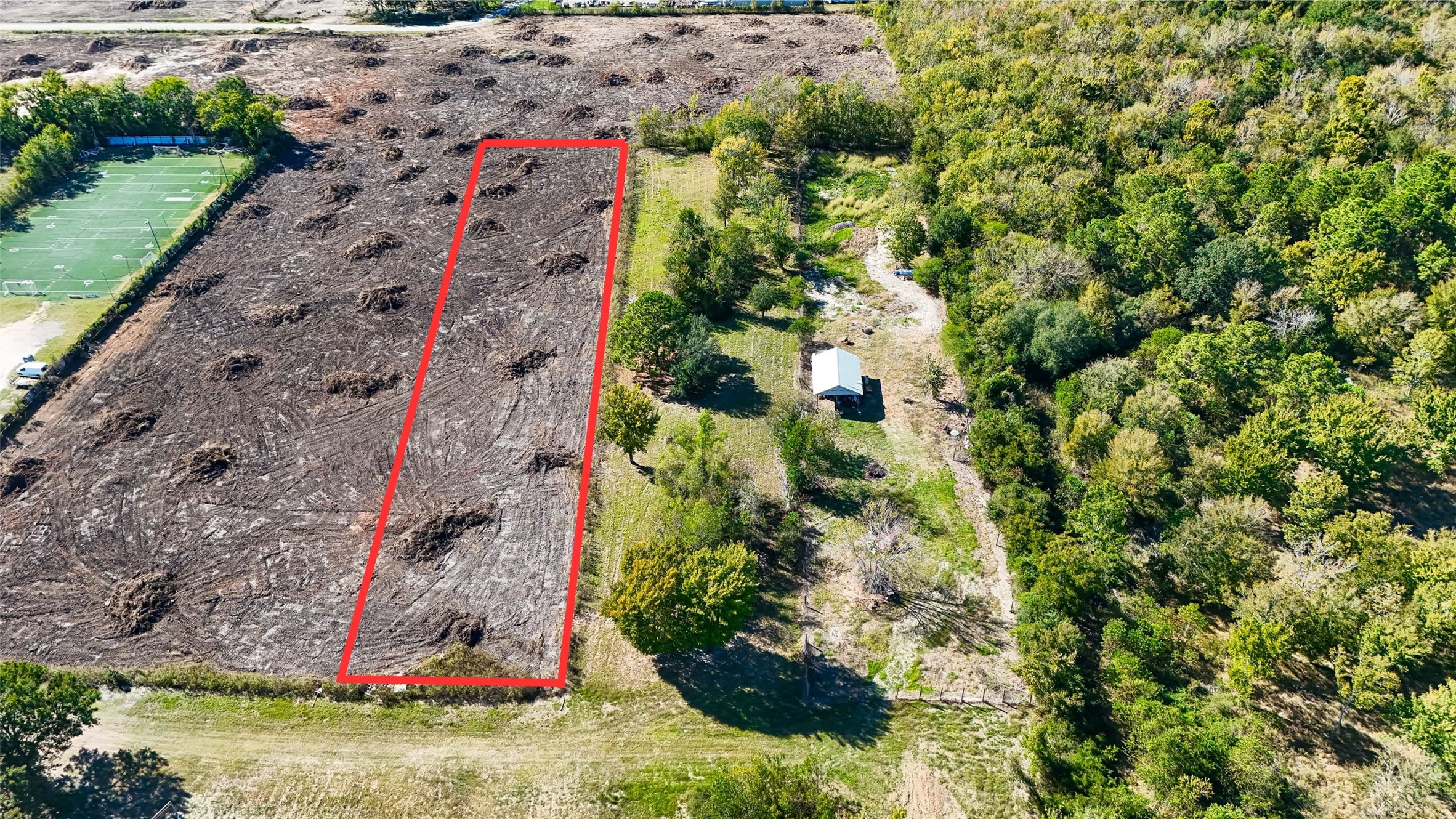 a backyard of a house with a yard and large trees