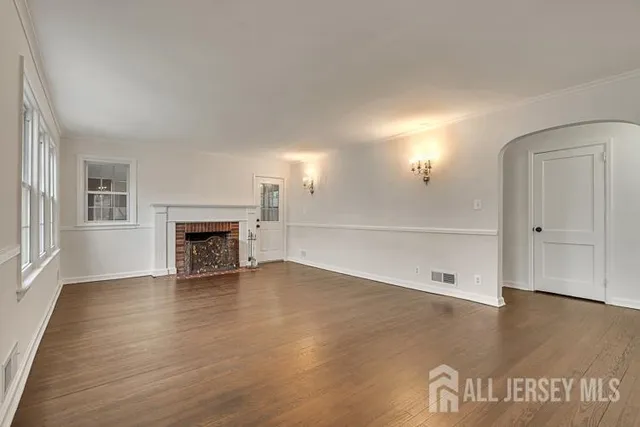 an empty room with wooden floor and fireplace