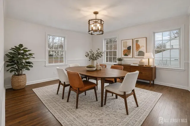 a dining room with furniture potted plants and wooden floor