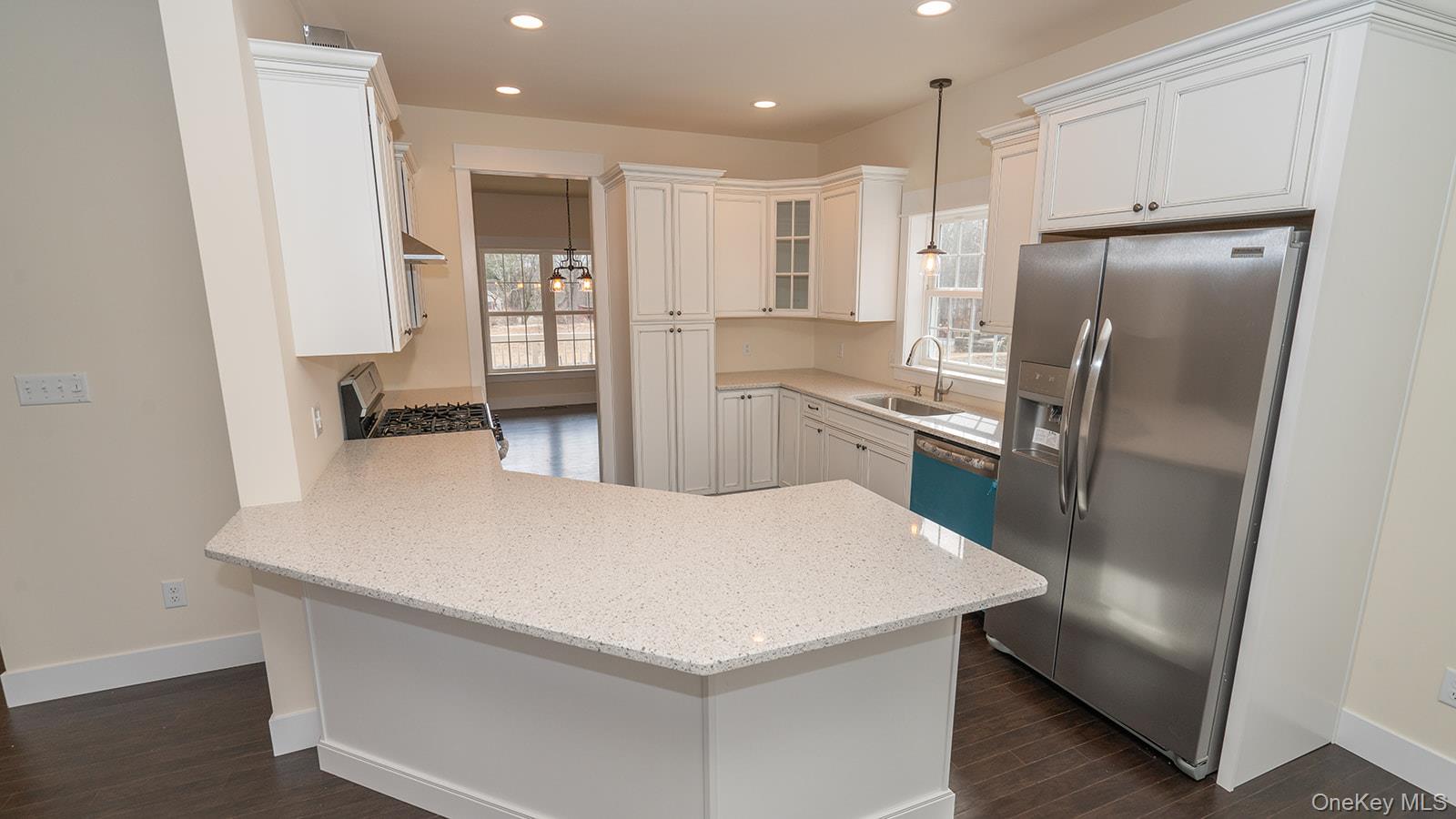 43 Malloy Road Wallkill, NY 12589 - Photo 2 of 50 Kitchen featuring glass insert cabinets, appliances with stainless steel finishes, a peninsula, light stone counters, and hanging light fixtures
