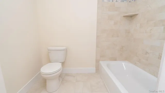 a white toilet sitting next to a bath tub
