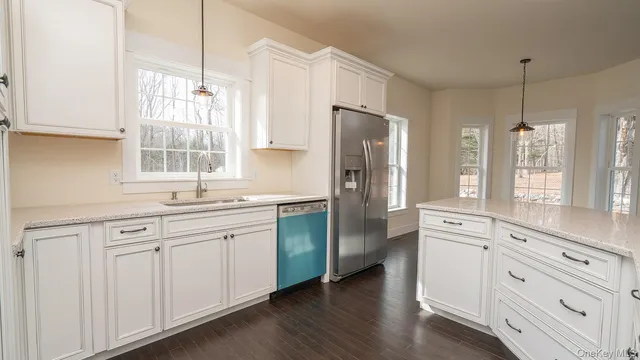 a kitchen with white cabinets and white stainless steel appliances