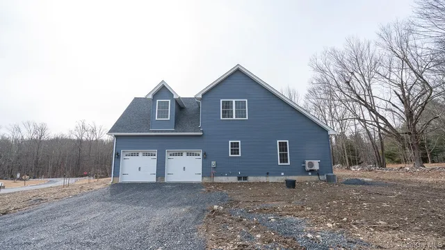 a view of a house with a yard and large tree