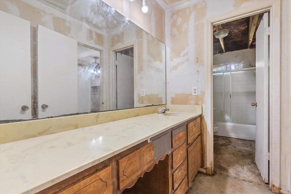317 Chapman Road Hewitt, TX 76643 - Photo 11 of 20 Bathroom vanity featuring a long countertop, single sink with faucet, and an expansive wall mirror