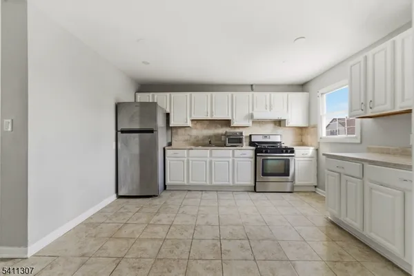 a kitchen with a stove sink and a refrigerator