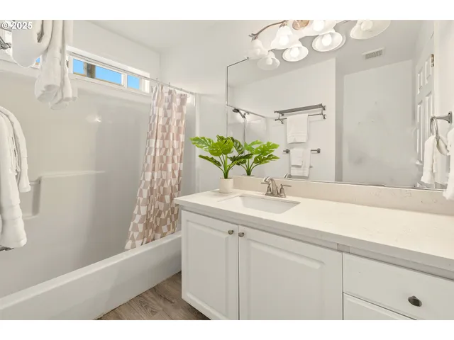 a bathroom with a sink vanity granite and a shower