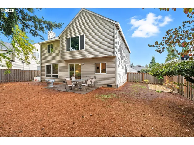 a view of a house with backyard and sitting area
