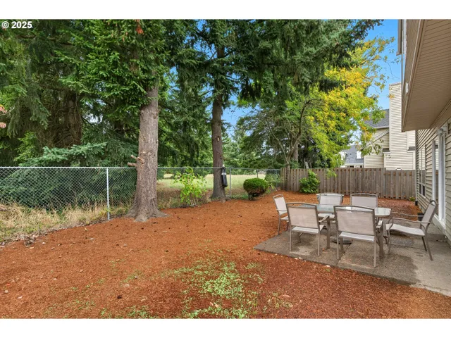 a backyard of a house with table and chairs