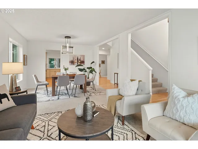 a living room with furniture a dining table and a chandelier