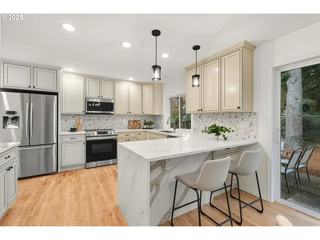a kitchen with kitchen island white cabinets and stainless steel appliances