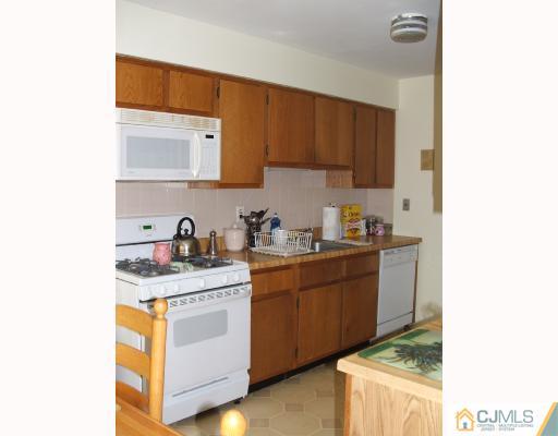 1530 Raspberry Court Edison, NJ 08817 - Photo 3 of 8 a kitchen with stainless steel appliances granite countertop a sink stove and cabinets