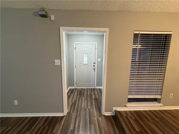 a view of a room with wooden floor and a window