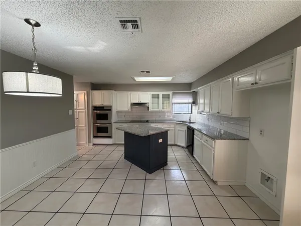 a kitchen with stainless steel appliances granite countertop a sink and cabinets
