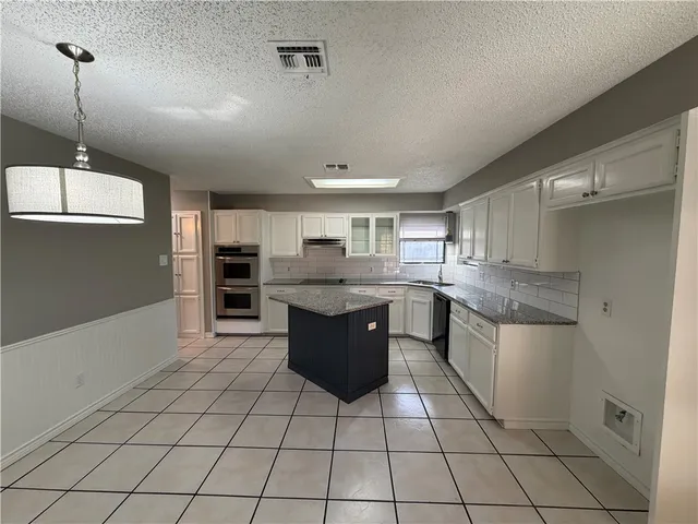 a kitchen with stainless steel appliances granite countertop a sink and cabinets