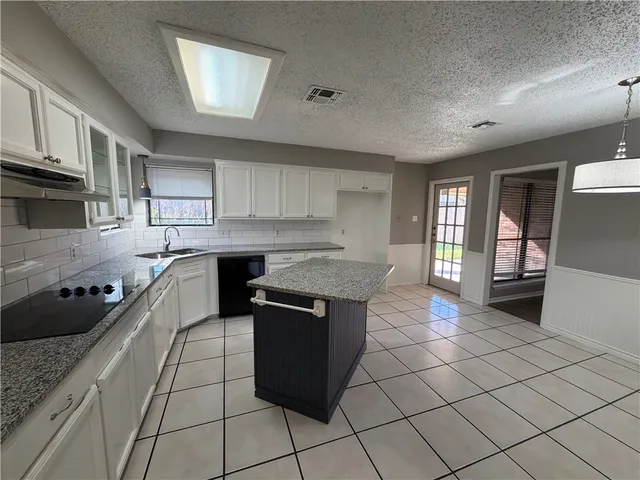 a kitchen with stainless steel appliances granite countertop a refrigerator a sink and a stove