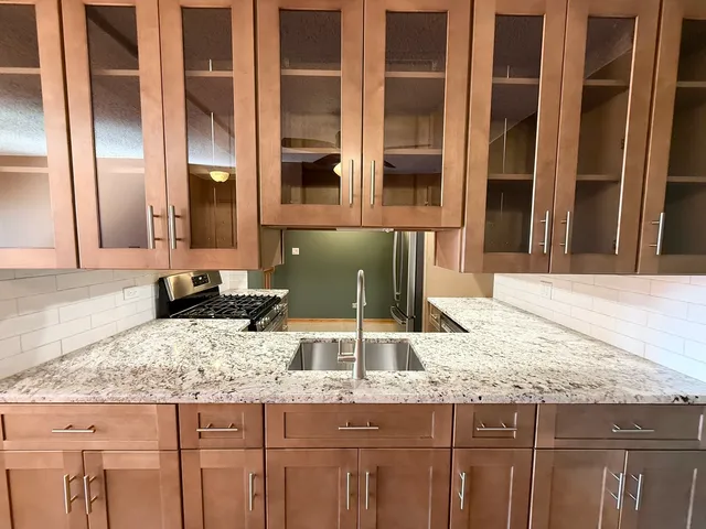 a hallway with granite countertop stainless steel appliances and sink