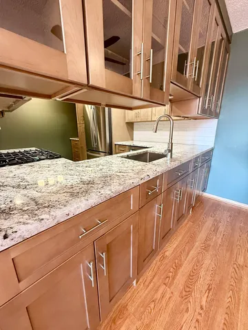 a kitchen with granite countertop cabinets sink and window