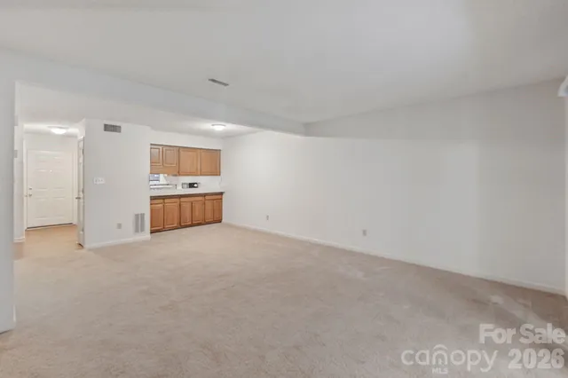 a view of empty room with kitchen