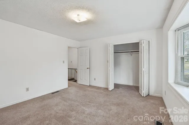 an empty room with windows and closet