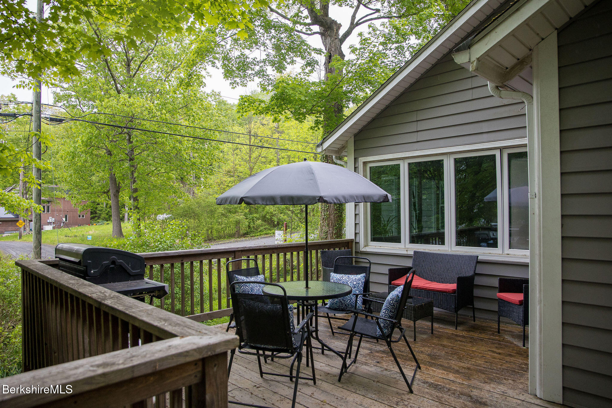 10 Elm Road Richmond, MA 01201 - Photo 6 of 32 a view of a roof deck with table and chairs under an umbrella