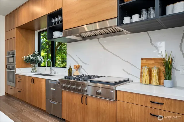 a kitchen with stainless steel appliances granite countertop a sink and a stove