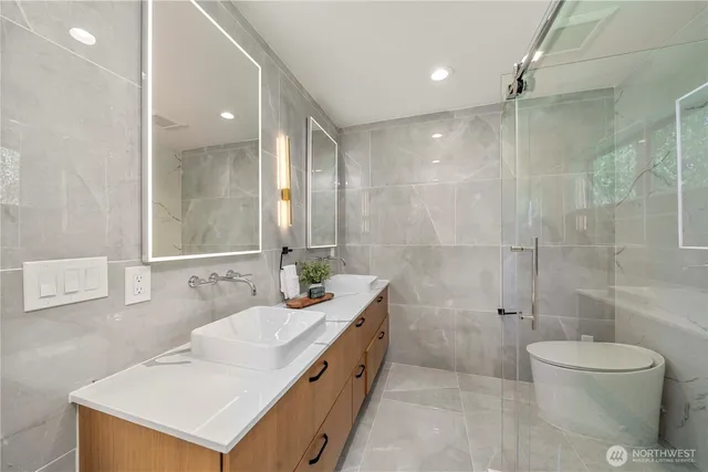 a bathroom with a double vanity sink toilet and shower