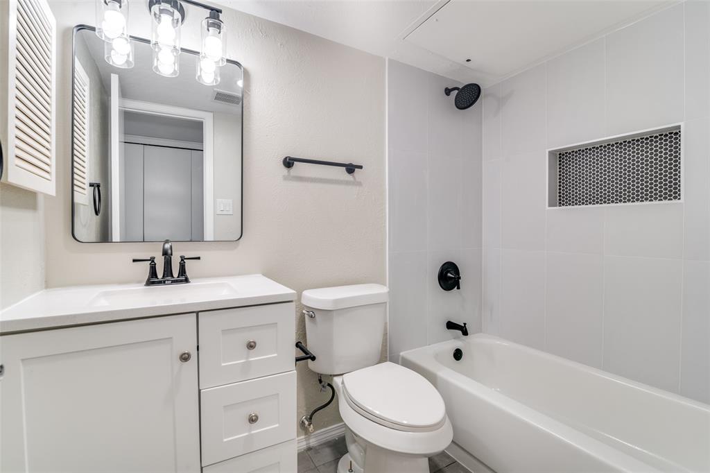 4017 Coryell Way Mesquite, TX 75150 - Photo 11 of 13 a bathroom with a toilet a sink a mirror a bathtub and vanity