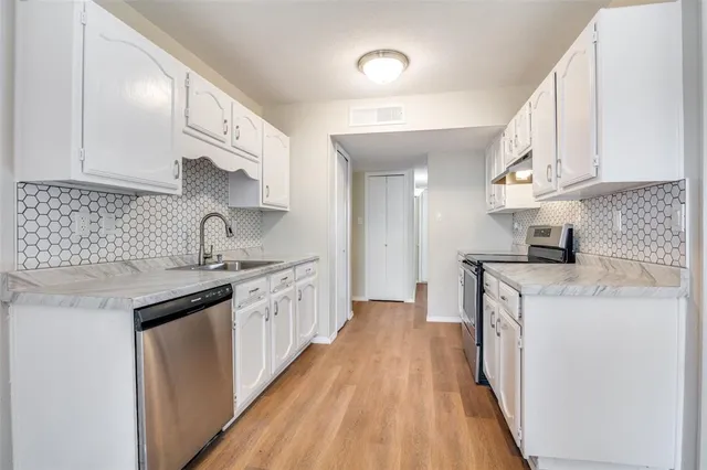 a kitchen with granite countertop a sink stove and cabinets