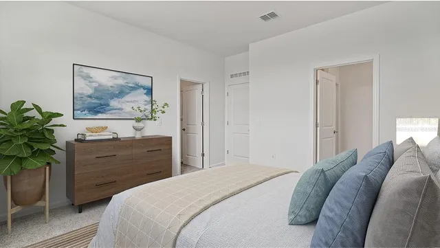 a bedroom with a bed potted plant and a window