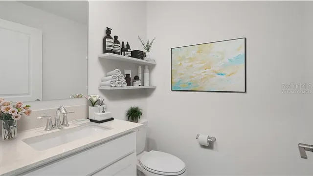 a bathroom with a sink mirror and toilet