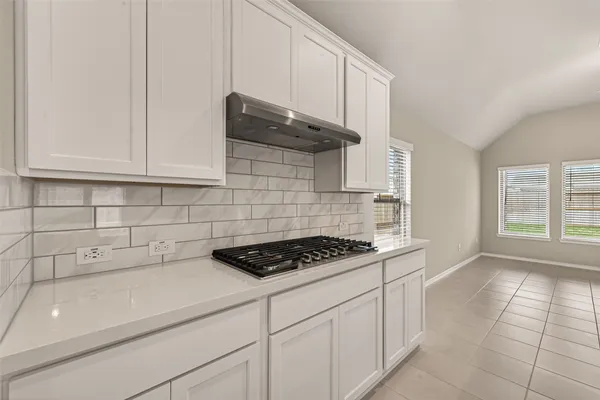 a kitchen with stainless steel appliances a cabinets and a stove top oven