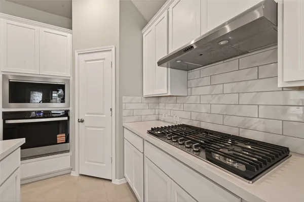 a stove top oven sitting inside of a kitchen