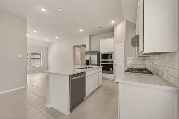 a kitchen with stainless steel appliances a stove a sink a microwave and cabinets