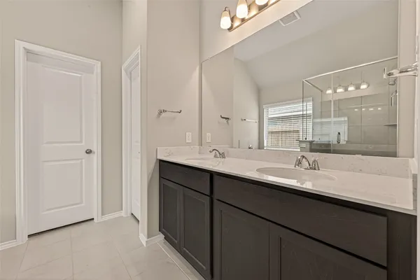 a bathroom with a double vanity sink and a mirror