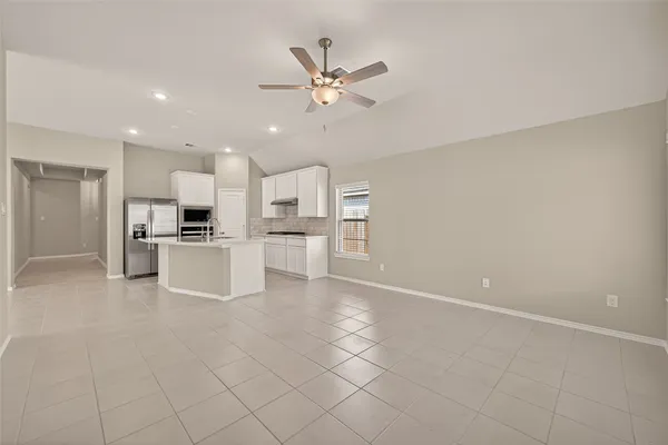 a view of kitchen with center island stainless steel appliances refrigerator sink and cabinets