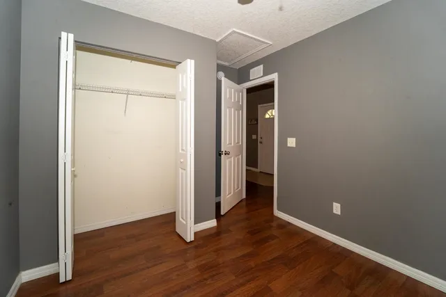 an empty room with wooden floor and closet