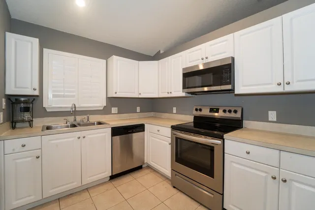 a kitchen with white cabinets stainless steel appliances and sink