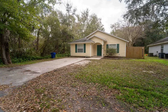 a white house that has a tree in front of it