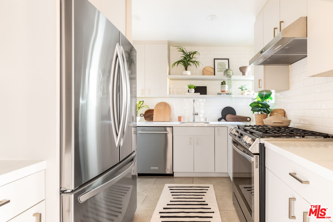 4804 Hollow Corner Road, Unit 125 Culver City, CA 90230 - Photo 13 of 43 a kitchen with a refrigerator and white cabinets