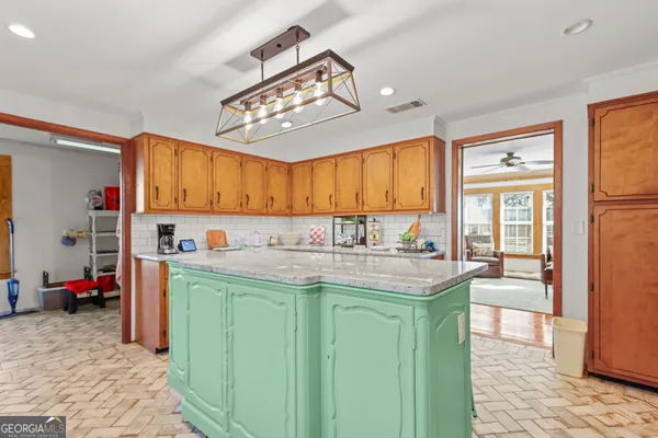 a view of a kitchen with kitchen island granite countertop a refrigerator oven a sink and a dining table view