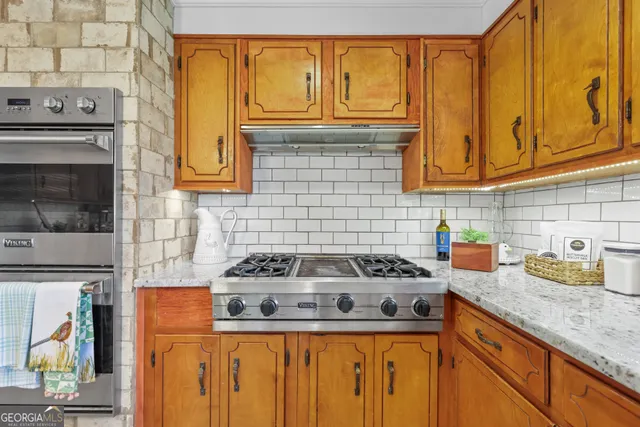 a kitchen with granite countertop cabinets and a stove top oven
