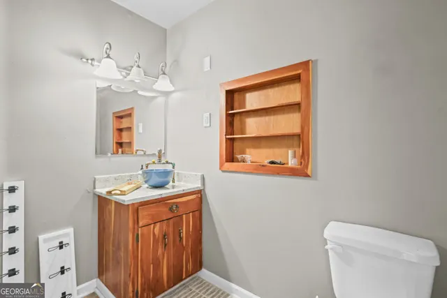 a bathroom with a sink a toilet and mirror