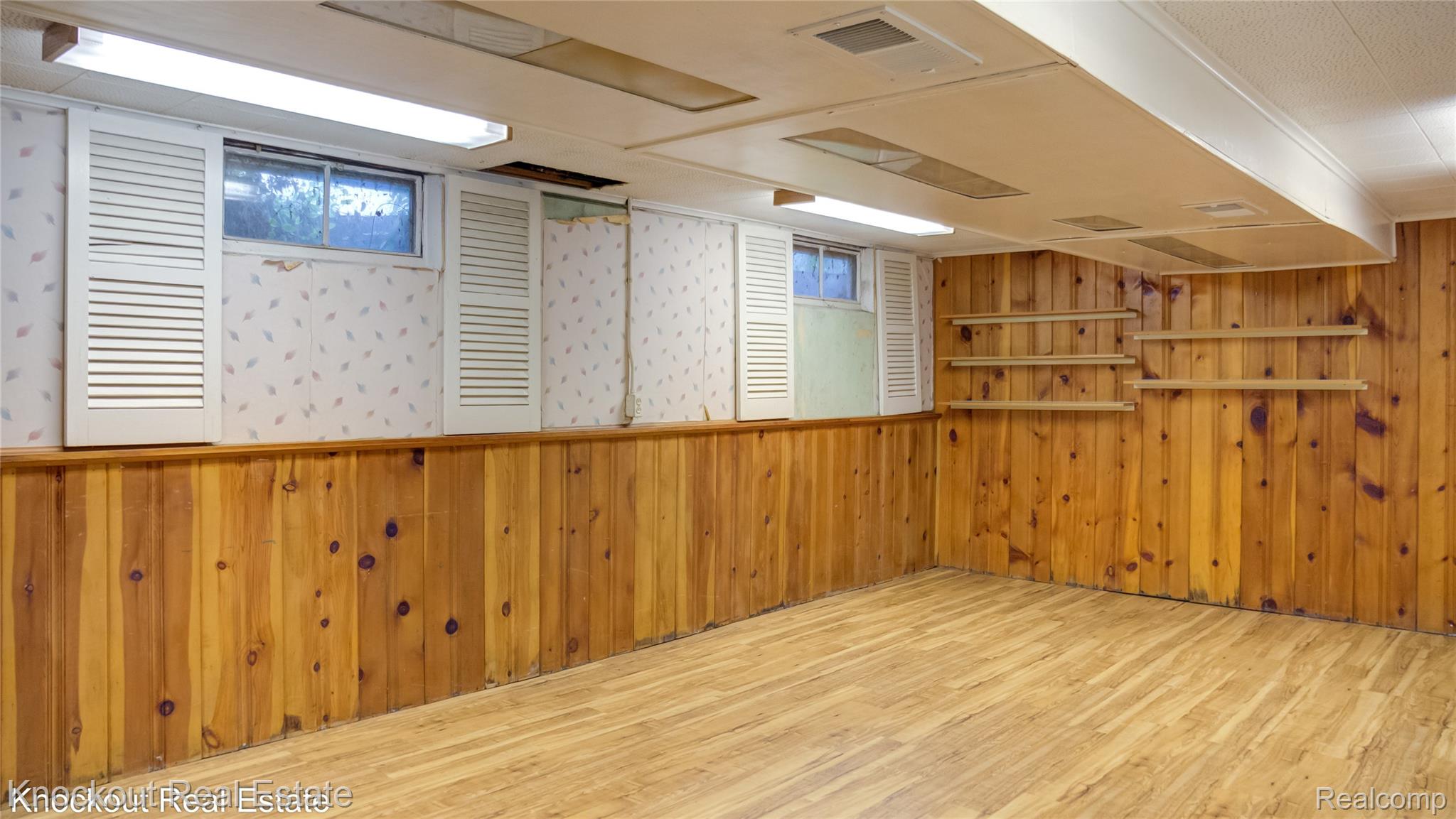 4465 Dirker Road Saginaw, MI 48638 - Photo 44 of 56 Spare room featuring wood finished floors and wooden walls